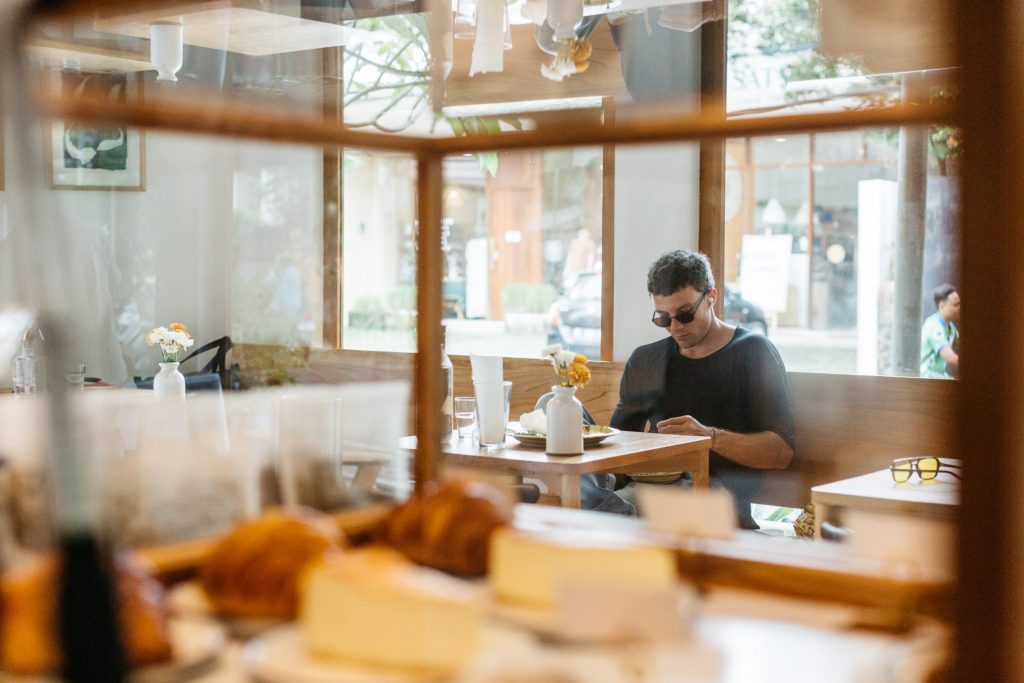 A man wearing sunglasses is sitting in Ame Bistro & Coffee.