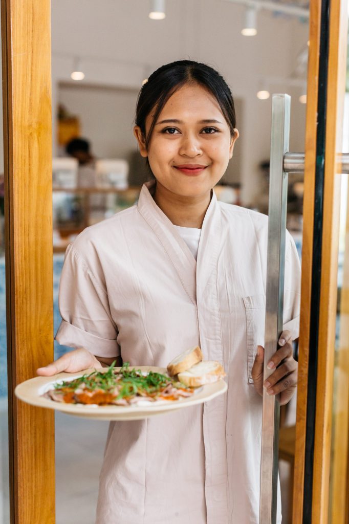 A smiling woman opened the door and brought a plate of salad.