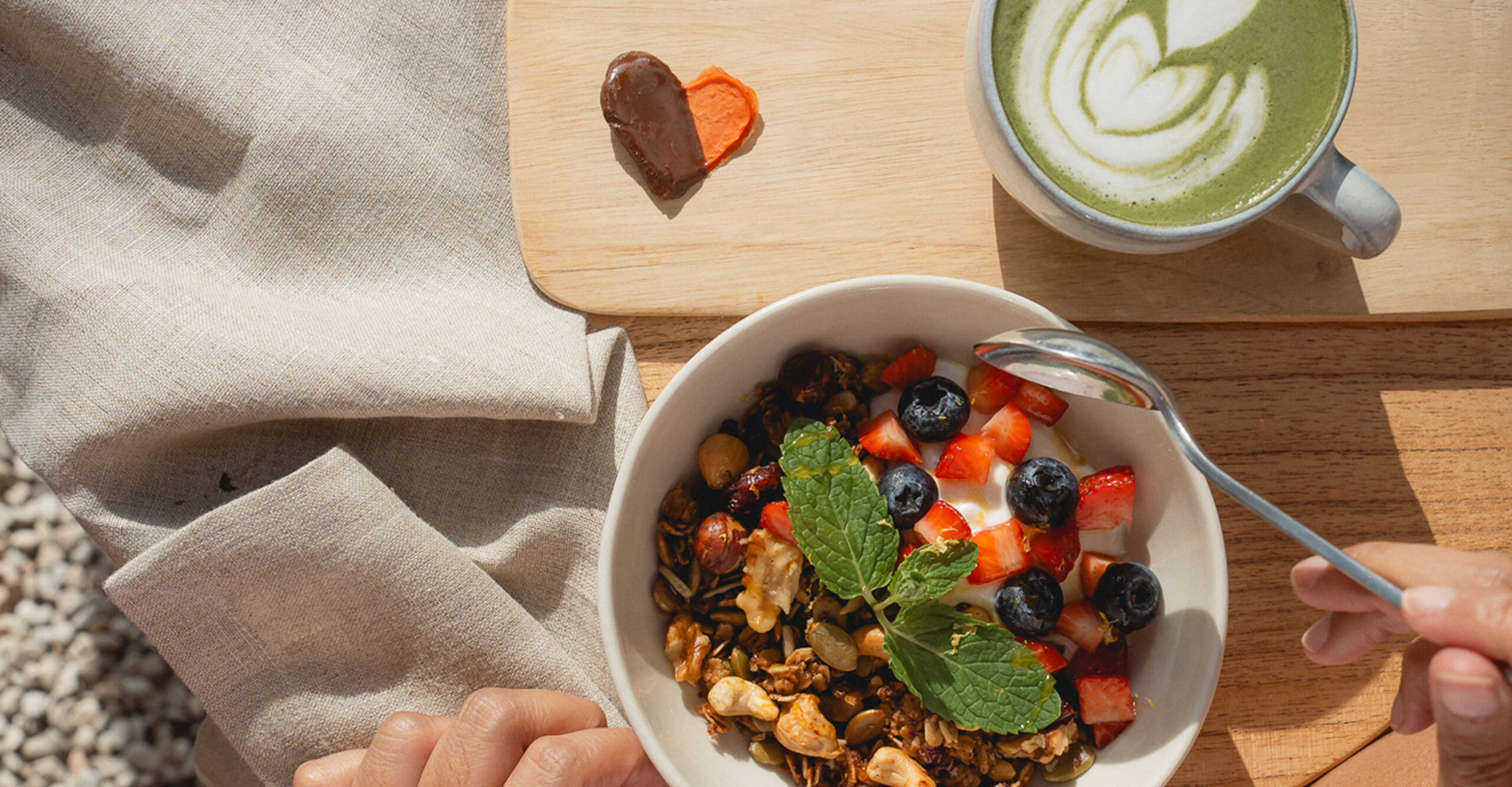 A bowl of smoothies with cup of matcha
