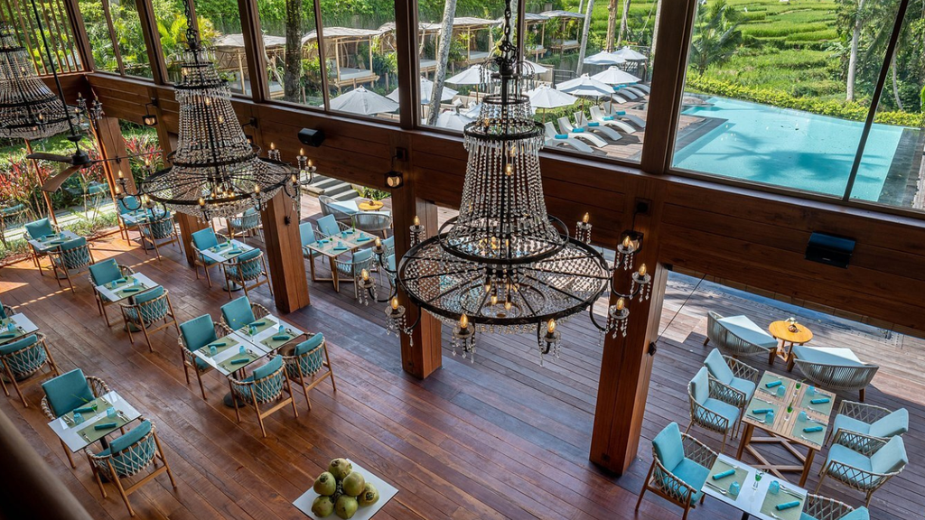 Open air restaurant surrounded by lush tropical plants and greenery in Ubud.